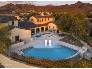 Stunning aerial view of a luxury home with a beautiful pool and mountain views at 19978 N 101St Pl, Scottsdale, AZ 85255