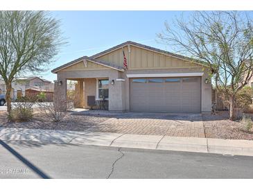 Charming single-story home featuring a two-car garage, desert landscaping, and a brick paver driveway at 20231 W Grant St, Buckeye, AZ 85326