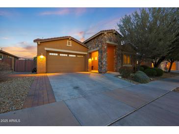 Charming single-Gathering home featuring a stone entrance, two-car garage, and well-manicured landscaping at 24117 N 165Th Dr, Surprise, AZ 85387