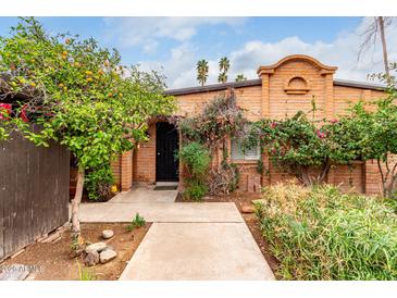 Charming brick home with a well-maintained yard, mature trees, and a welcoming front entrance with an arched entryway at 3046 N 32Nd St # 328, Phoenix, AZ 85018