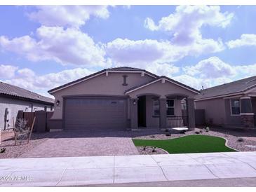 Charming single-story home featuring a brick driveway, two-car garage, and manicured front lawn at 34997 N Sacramento Wash Rd, San Tan Valley, AZ 85144