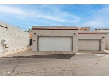 A view of the home's exterior featuring a white exterior, garage doors, and unit numbers at 4721 W Eva St, Glendale, AZ 85302