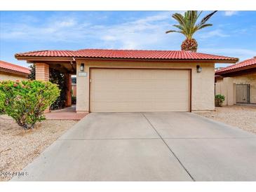 A single car garage with a red tile roof and desert landscaping in front at 5217 E Tunder Cir, Phoenix, AZ 85044