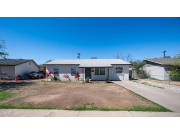 Charming single-story home with well-maintained landscaping, blue sky, and a long driveway at 5638 N 61St Ln, Glendale, AZ 85301