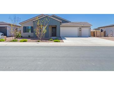 Charming single-story home with a three-car garage, desert landscaping, and a modern exterior paint scheme at 8025 W Gardenia Ave, Glendale, AZ 85303