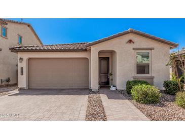 Charming single-story home featuring a two-car garage, paver driveway, and manicured landscaping at 12125 W Levi Dr, Avondale, AZ 85323