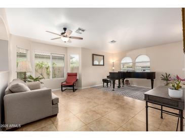 Inviting living room with neutral paint, tile floors, and many windows at 17532 W Caribbean Ln, Surprise, AZ 85388