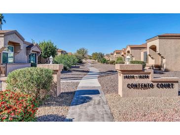 View of Contento Court with well-maintained landscaping and walkways under a clear blue sky at 18254 N 136Th Ave, Sun City West, AZ 85375