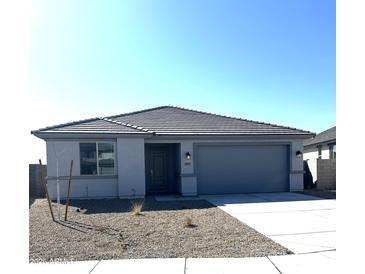 Charming single-story home featuring a gray color scheme, concrete driveway, and low maintenance landscaping at 18347 W Monte Lindo Ln, Surprise, AZ 85387