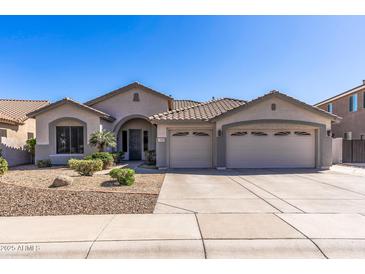 Charming single-story home featuring a three-car garage, desert landscaping, and a tile roof at 7329 W Tether Trl, Peoria, AZ 85383