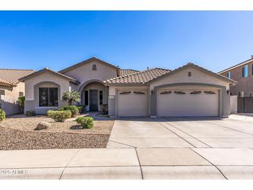 Beautiful single-story home with a three-car garage and well-manicured desert landscaping at 7329 W Tether Trl, Peoria, AZ 85383