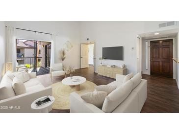 Bright living room with modern decor, balcony access, and hardwood floors at 9445 N 94Th Pl # 212, Scottsdale, AZ 85258