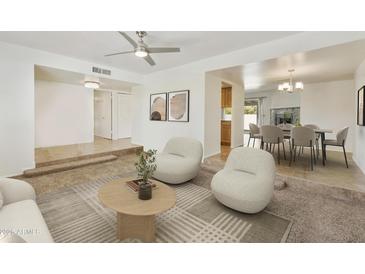 Bright living room with modern furnishings, neutral tones, and open access to dining area at 15218 N 37Th Ave, Phoenix, AZ 85053