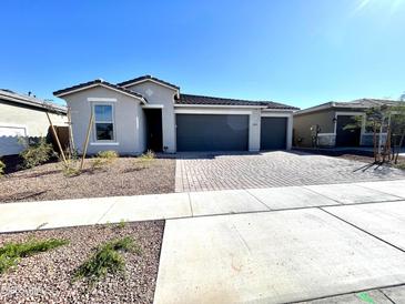 Charming single-story home featuring a three-car garage and well-manicured front yard at 17829 W Red Fox Rd, Surprise, AZ 85387