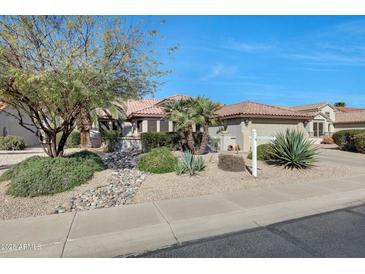 Charming single-story home featuring desert landscaping, a red tile roof and neutral color palette at 18102 N Petrified Forest Dr, Surprise, AZ 85374