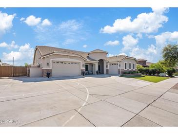 Expansive home with a circular driveway, three-car garage, and well-maintained landscaping at 21921 E Domingo Rd, Queen Creek, AZ 85142