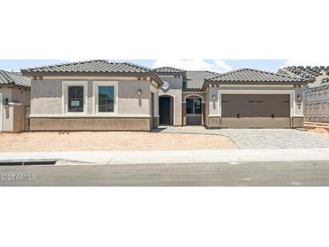 Charming home exterior features desert landscaping, a two-car garage, and a tile roof at 26664 W Siesta Ln, Buckeye, AZ 85396
