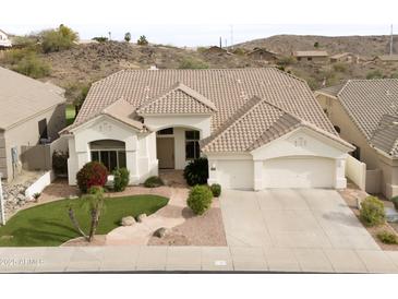 Charming single-story home featuring a well-manicured lawn, tile roof, and attached two car garage at 301 E Ashurst Dr, Phoenix, AZ 85048