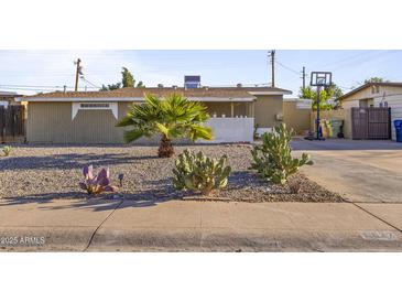 Charming single-story home with a minimalist rock garden in the front yard at 6627 W Keim Dr, Glendale, AZ 85301