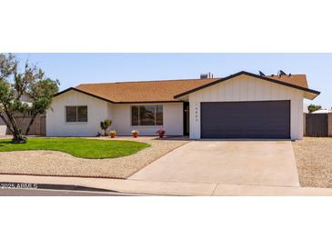 Charming single-story home with a well-manicured lawn, gravel landscaping, and a two-car garage at 14803 N 55Th Ave, Glendale, AZ 85306