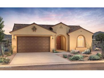 Inviting single-story home featuring a two-car garage, covered entry, and desert landscaping at 21287 N 272Nd Ln, Buckeye, AZ 85396