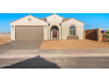 Charming single-story home featuring a neutral color palette, a two-car garage, and a welcoming front entrance at 21287 N 272Nd Ln, Buckeye, AZ 85396