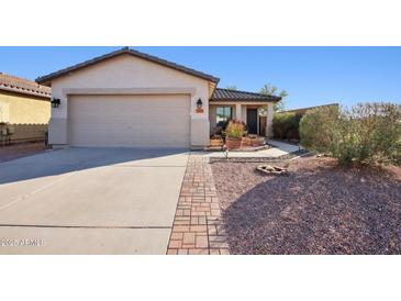 Charming single-story home featuring a desert landscape, brick walkway and two car garage at 325 W Angus Rd, San Tan Valley, AZ 85143