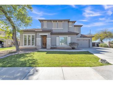 Charming two-story home featuring a well-manicured lawn and a neutral-toned exterior with stone accents at 3419 E Rosa Ln, Gilbert, AZ 85297