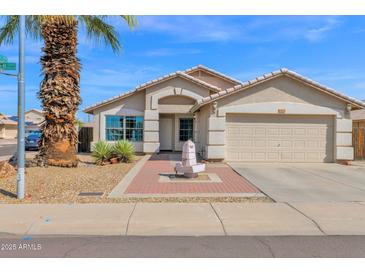 Charming single-story home featuring a desert landscape, palm tree, and a quaint water fountain at 6904 W Golden Ln, Peoria, AZ 85345