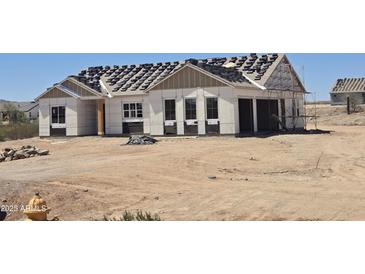 Under construction home with visible exterior and roof tiles ready for installation in a desert landscape at 1800 W Caramel Ct, Queen Creek, AZ 85144