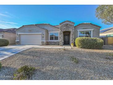 Charming single-story home featuring stone accents, a two-car garage, and low maintenance desert landscaping at 30116 W Fairmount Ave, Buckeye, AZ 85396