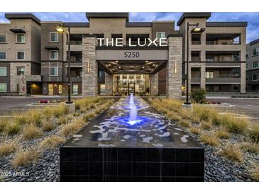 Stunning exterior view of 'The Luxe' building with a beautiful water feature and well-manicured landscaping at 5250 E Deer Valley Dr # 343, Phoenix, AZ 85054