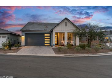 Charming single-story home with a modern garage door and inviting front porch at 5644 N 206Th Gln, Buckeye, AZ 85396