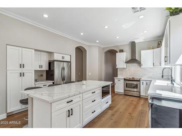 Bright kitchen with a large center island, stainless steel appliances, and hardwood floors at 7919 E Posada Ave, Mesa, AZ 85212