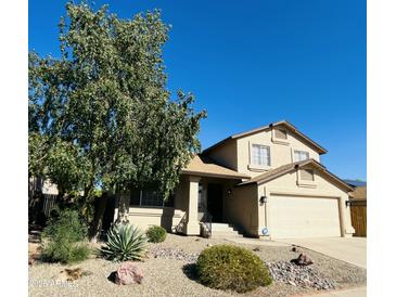 Tan two-story home with a large tree in the front yard and a two car garage at 24809 N 41 Ave, Glendale, AZ 85310