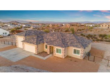 The home features a three car garage, rock accents, neutral colors and easy-care landscaping at 28319 N Marchant Trce, Queen Creek, AZ 85144
