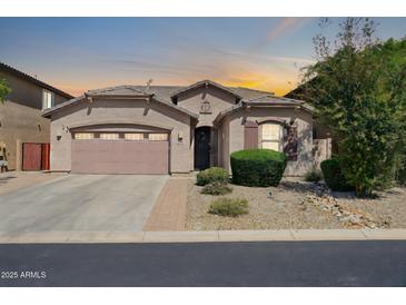 Inviting single-story home featuring a two-car garage and desert landscaping, with a warm color scheme at 7576 W Fetlock Trl, Peoria, AZ 85383