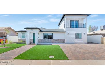 Beautiful home exterior featuring a balcony, manicured lawn, and brick accents, offering curb appeal at 92 N Palm St, Gilbert, AZ 85234