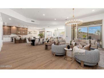 Bright open-concept living area featuring a chandelier, modern furnishings, and seamless indoor-outdoor flow to the patio at 11267 E Beck Ln, Scottsdale, AZ 85255