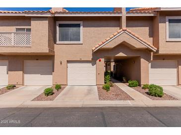 Charming townhome with private garage, covered entry, and well-maintained landscaping for a welcoming curb appeal at 1633 E Lakeside Dr # 106, Gilbert, AZ 85234