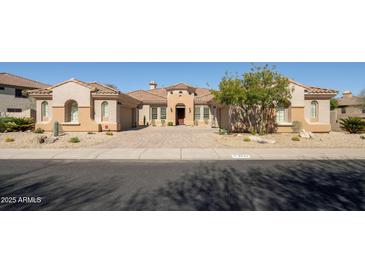 Stunning single-story home with a tile roof, well-manicured landscaping, and a circular paver driveway at 3822 E Tracker Trl, Phoenix, AZ 85050