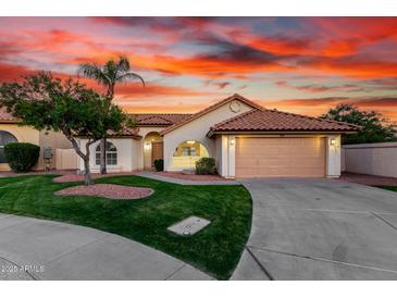 Inviting single-Gathering home featuring a two-car garage, lush green lawn, and southwestern landscaping at 3861 S Acacia Ct, Chandler, AZ 85248