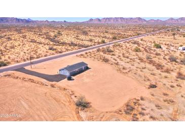 Stunning aerial view of a desert home with extensive land and nearby mountain range at 50426 W Wildwood Rd, Maricopa, AZ 85139