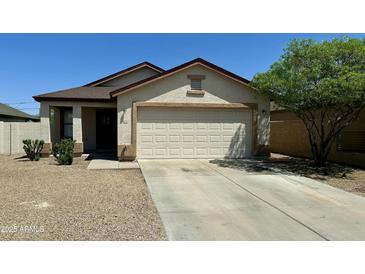 Beige single-story home featuring a two-car garage, low maintenance desert landscaping and concrete driveway at 592 E 9Th Ave, Apache Junction, AZ 85119
