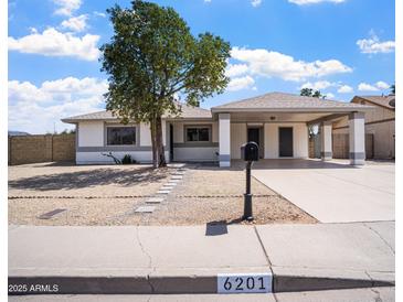 Charming single-story home with a covered parking and low-maintenance landscaping at 6201 W Acoma Dr, Glendale, AZ 85306