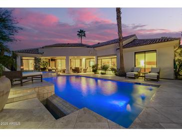 Luxurious backyard pool illuminated against a vibrant dusk sky, offering a serene oasis at 7380 E Turquoise Ave, Scottsdale, AZ 85258
