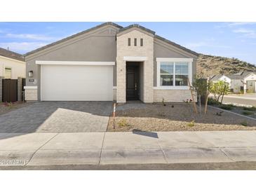 Charming single-Gathering home featuring a two-car garage, stone accents, and desert landscaping at 17801 W Mission Ln, Waddell, AZ 85355