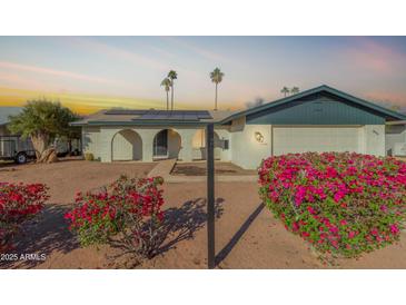 Charming single-Gathering home featuring brick accents, a front yard with mature landscaping, and a two-car garage at 624 E Laguna Dr, Tempe, AZ 85282