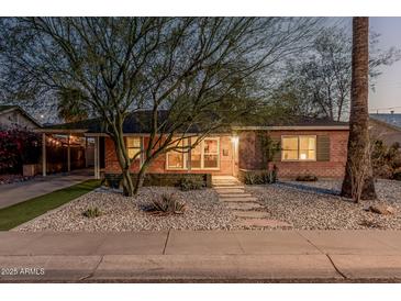 Charming brick home featuring desert landscaping, stepping stones, and a covered parking area at 1513 W Mitchell Dr, Phoenix, AZ 85015
