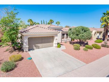 Inviting one-story home with a large driveway, desert landscaping, and a well-maintained tile roof at 22236 N Arrellaga Dr, Sun City West, AZ 85375